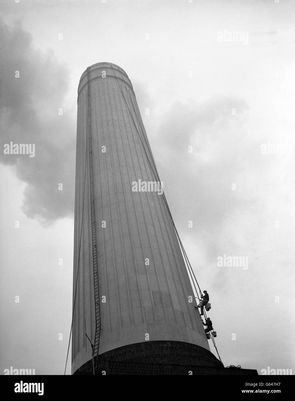 Die Steeplejacks Harry Walker, 49, und Harry Braham, 38, nahe der Basis eines 350 Meter hohen Schornsteins im Battersea Power Station. Sie haben den Kamin neu lackiert, wobei sie dabei 110 Gallonen gummierte Farbe verwendeten. Stockfoto