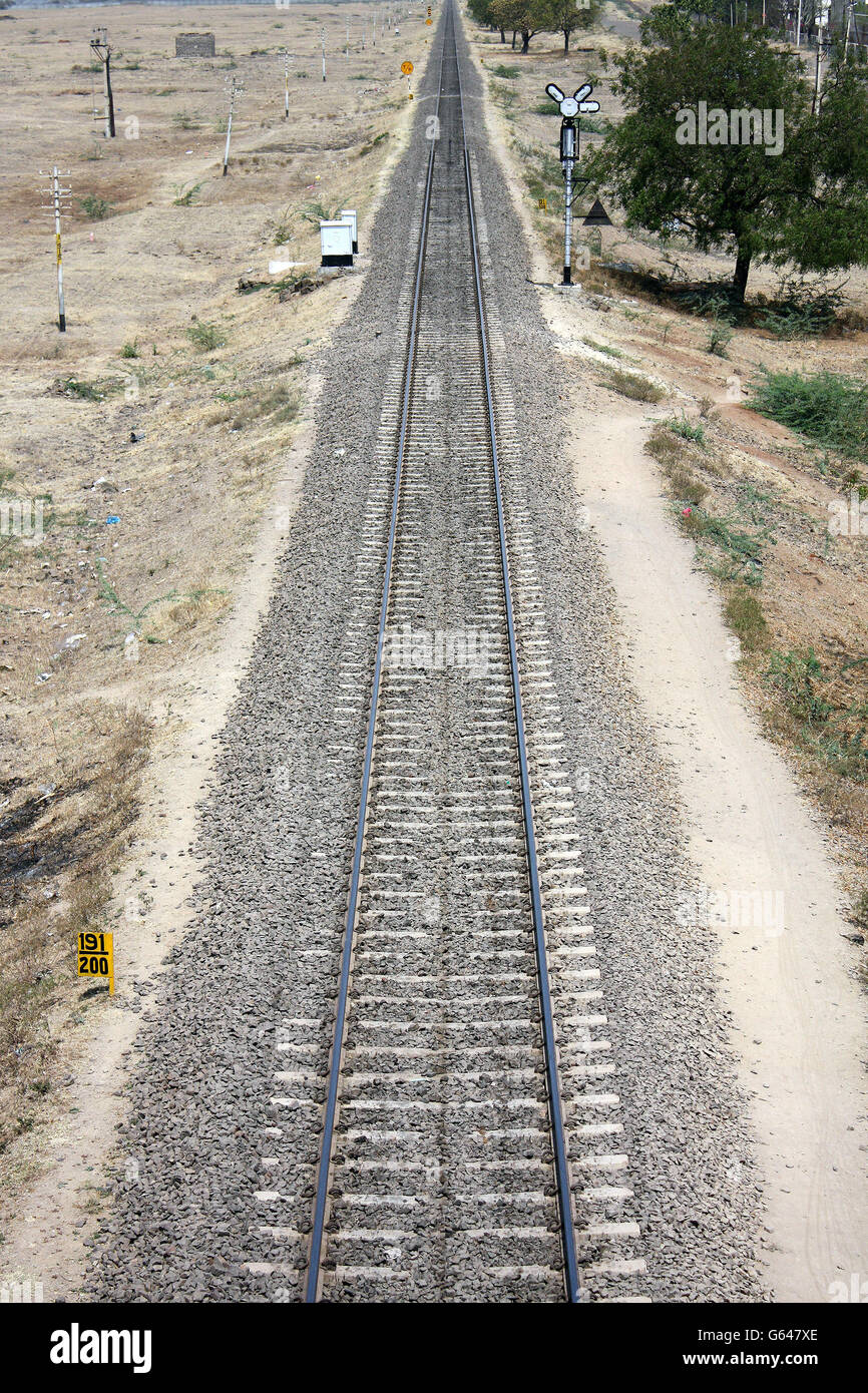 Ein Blick auf einem langen Gleis in Richtung Horizont, in der indischen Landschaft. Stockfoto
