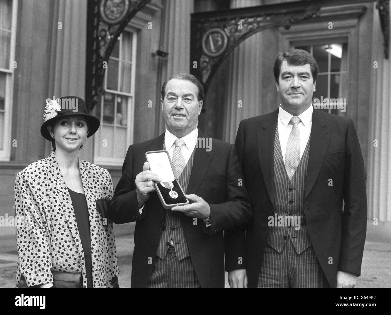 Sir Albert McQuarrie im Buckingham Palace, um von der Queen zum Ritter geschlagen zu werden. Mit ihm ist sein Sohn Dermot und seine Schwiegertochter Elisabeth. Stockfoto