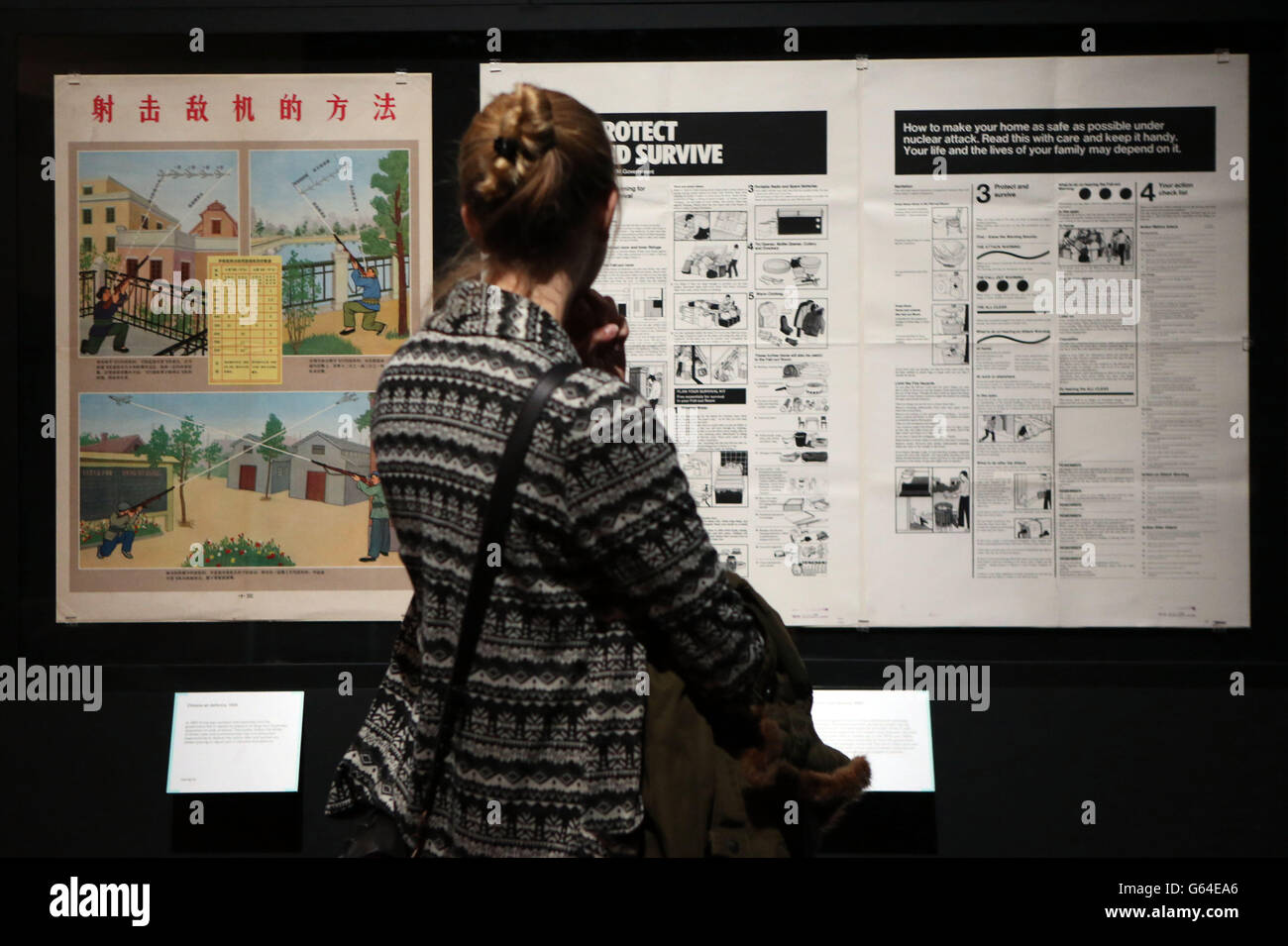 Eine Frau betrachtet Plakate, die im Rahmen der Ausstellung Propaganda: Power and Persuasion in der British Library im Zentrum von London ausgestellt werden. Stockfoto