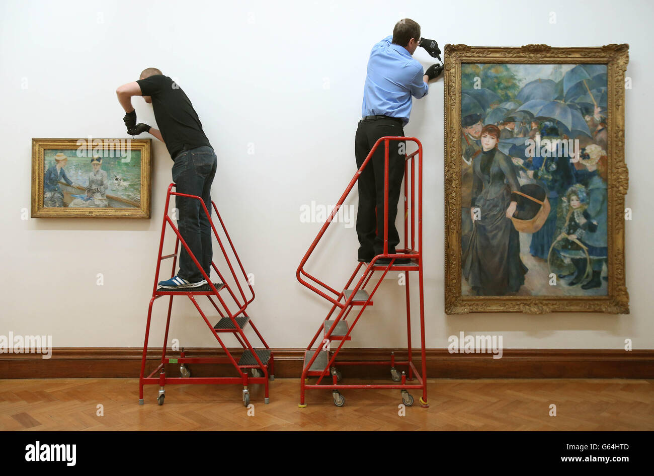 (Von links nach rechts) die Kunsthandler Dave McAsey und Peter Belling Hang Manets Jour d'Ete (Summers Day) Left und Renoirs 'Les Parapluies' (die Regenschirme), während vier impressionistische Gemälde von der National Gallery London an die Hugh Lane Gallery, Dublin, zurückgegeben werden. Stockfoto
