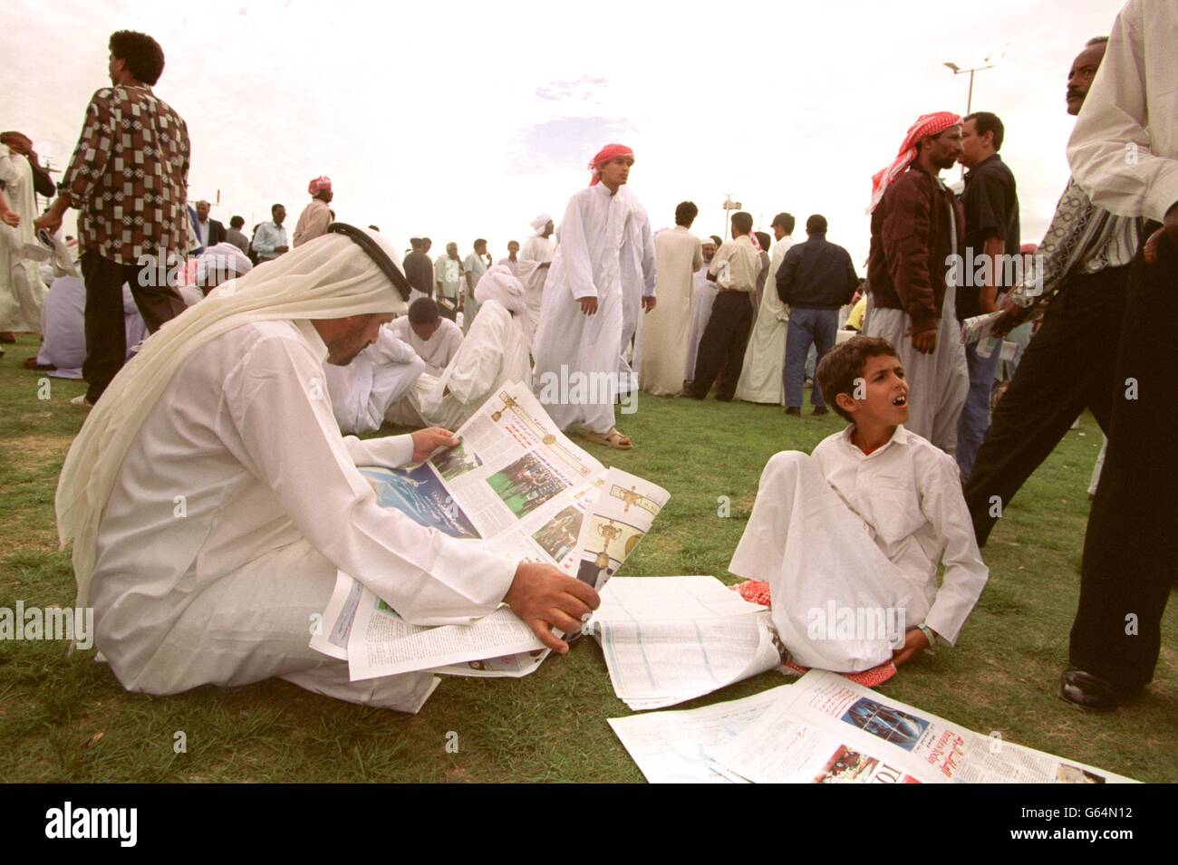 PFERDERENNEN - die Dubai World Cup in nad al Sheba. Vor der WM in Dubai bilden sich in der öffentlichen Einhausung Rennfahrerstudien aus einer lokalen Zeitung Stockfoto