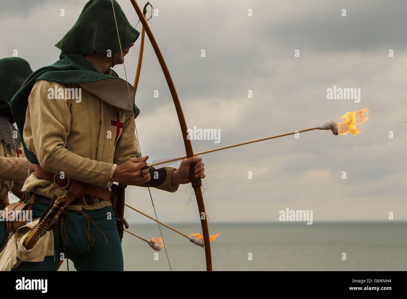 Bogenschützen der Purbrook Bowmen, gekleidet in Tudor-Kleidung, feuern von Southsea Castle aus eine Fülle flammender Pfeile in den Solent, wo die Mary Rose 1545 sank. Stockfoto
