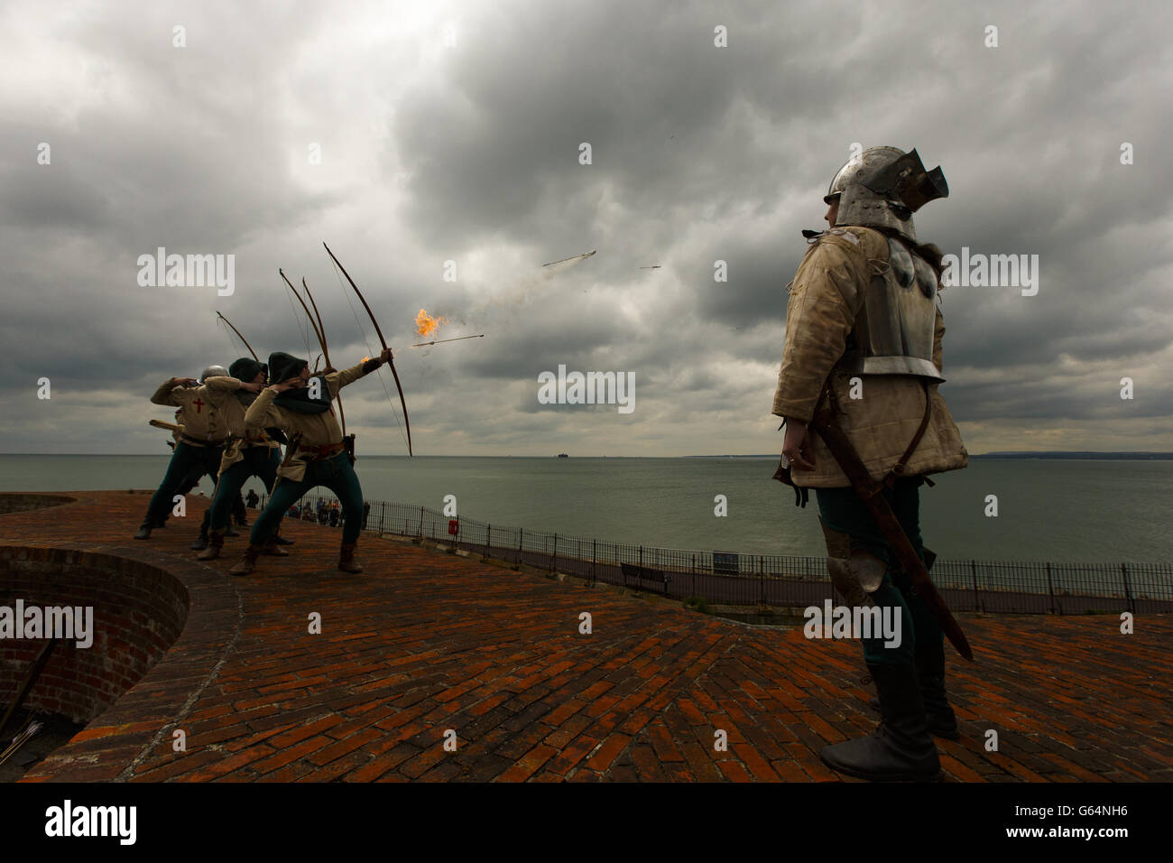 Bogenschützen der Purbrook Bowmen, gekleidet in Tudor-Kleidung, feuern von Southsea Castle aus eine Fülle flammender Pfeile in den Solent, wo die Mary Rose 1545 sank. Stockfoto