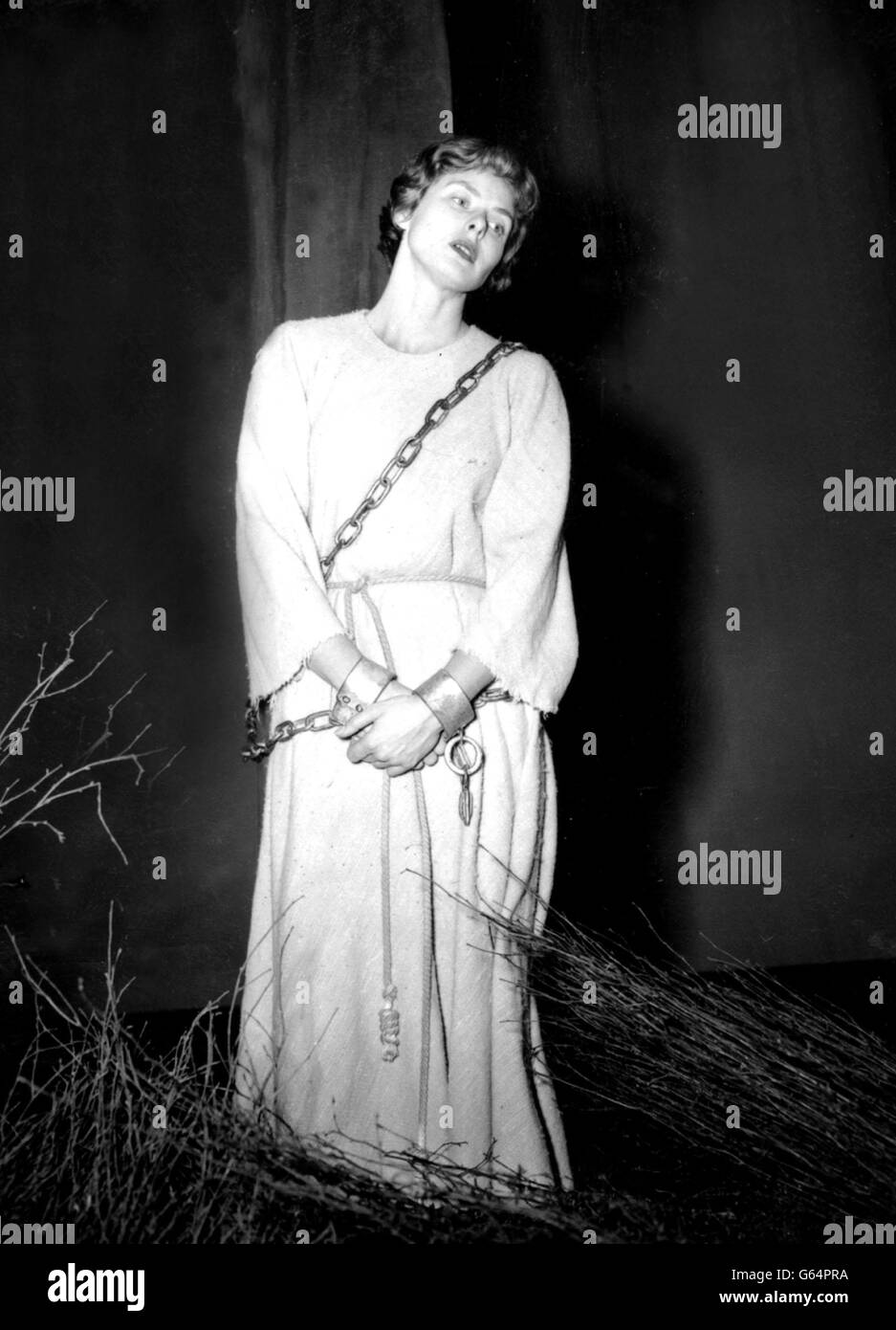 Ingrid Bergman als Jeanne d.. Jeanne d'Arc - Ingrid Bergman - wird in Ketten und mit Menschenhand auf dem Scheiterhaufen des Stoll Theatre, London, gesehen. Stockfoto