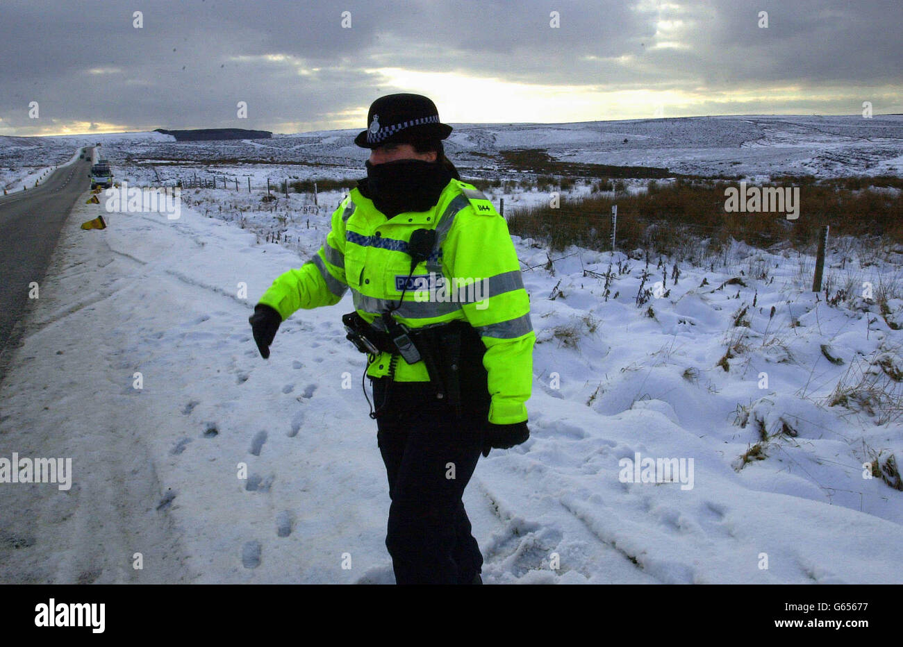 Eine Polizistin schützt ihr Gesicht vor Kälte, während sie für den Besuch des Verteidigungsministers Geoff Hoon bei der RAF Fylingdales in den North Yorkshire Moors im Dienst ist. Stockfoto