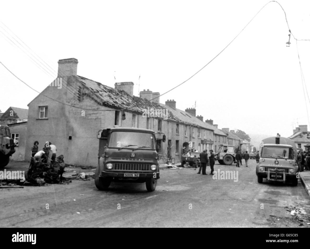 Einst ein friedliches Dorf in Ulster, heute eine Straße der Zerstörung. Das war Claudy, als Männer mit Lastwagen taten, was sie konnten, um nach den Autobombenexplosionen, bei denen sechs Menschen ums Leben kamen, aufzuräumen. Stockfoto