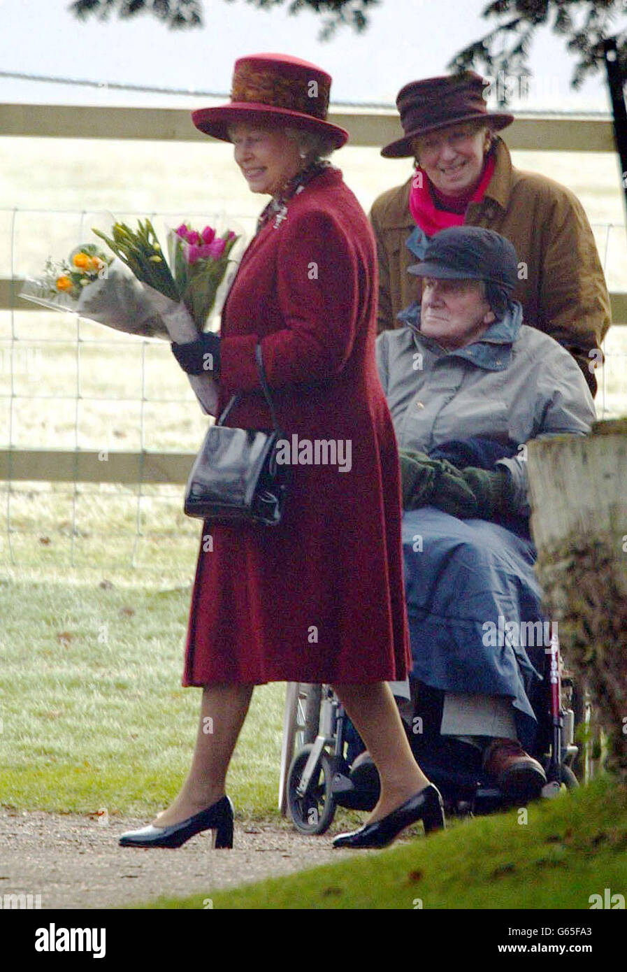 Die Königin erhält Blumen nach dem Gottesdienst in der St. Mary's Church auf dem Sandringham Estate. Stockfoto