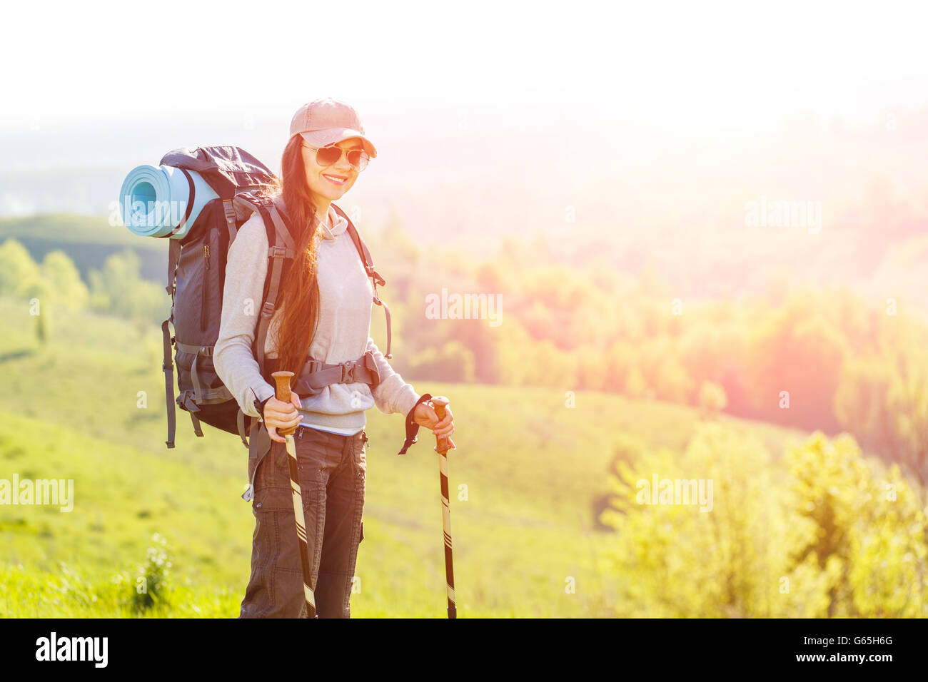 Junge Backpacker Wandern Frau stand an der Spitze der grünen Hügel. Wandern, Rucksackwandern Hintergrund mit Textfreiraum Stockfoto