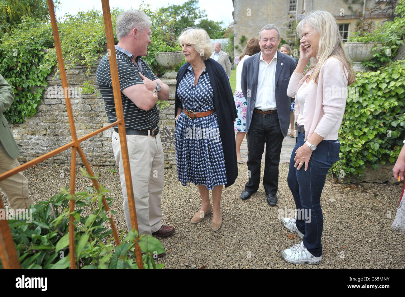 Die Herzogin von Cornwall spricht mit dem Gärtner Frank Powell mit dem Pink Floyd-Schlagzeuger Nick Mason und seiner Frau Annette während eines Besuchs im Middlewick House in Pickwick, Wiltshire, dem Zuhause des Pink Floyd-Schlagzeugers Nick Mason, der einen gemeinnützigen Tag der offenen Tür veranstaltet. Stockfoto