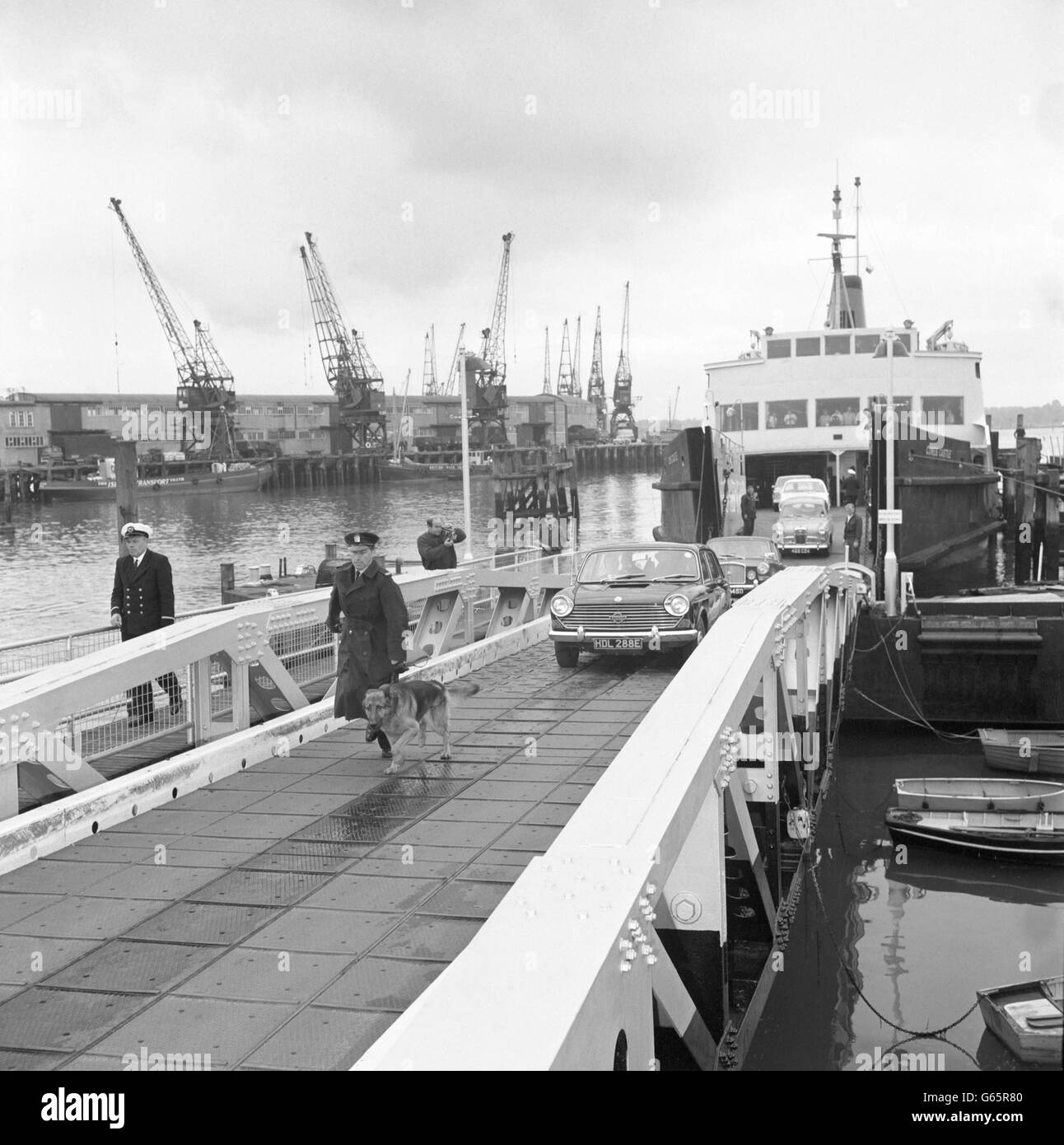 Ein Warder mit einem Verfolgerhund führt ein Auto mit zwei Aufsehern und dem 56-jährigen Spion Peter Kroger. Er wurde von Parkhurst auf der Isle of Wight in ein Gefängnis auf dem Festland verlegt. Er und seine Frau wurden für 20 Jahre Gefängnis wegen ihrer Beteiligung an dem Portland Secrets Case. Stockfoto