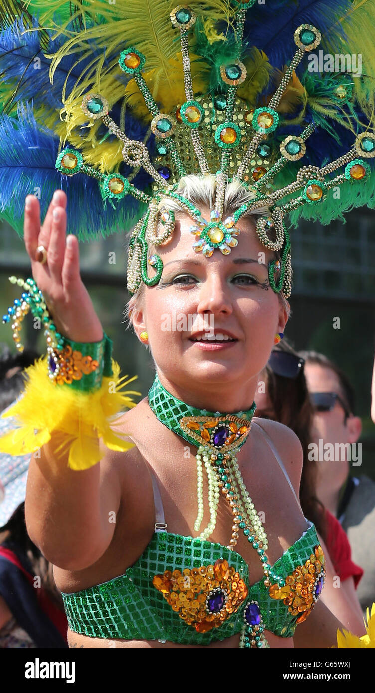 Ein Mitglied der Edinburgh Samba-Gruppe, als sie an der Mardis Gras Parade teilnehmen, die von Menschenmassen auf der Byres Road in Glasgow beobachtet wird. Rund 600 Teilnehmer nahmen an der Straßenparade Teil, um das West End Festival zu beginnen, an dem rund 70,000 Menschen teilnehmen werden. Stockfoto