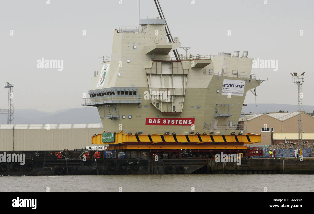 Der hintere Inselabschnitt des Flugzeugträgers der Queen Elizabeth-Klasse wird vor dem Transport nach Rosyth auf eine Barge der BAE Systems Werft in Glasgow verladen. Stockfoto