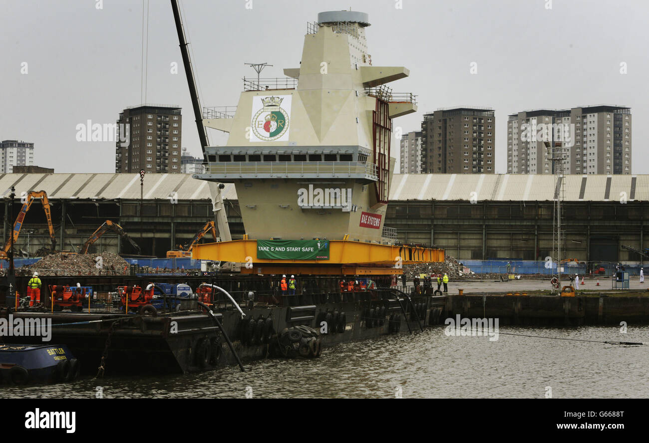 Der hintere Inselabschnitt des Flugzeugträgers der Queen Elizabeth-Klasse wird vor dem Transport nach Rosyth auf eine Barge der BAE Systems Werft in Glasgow verladen. Stockfoto