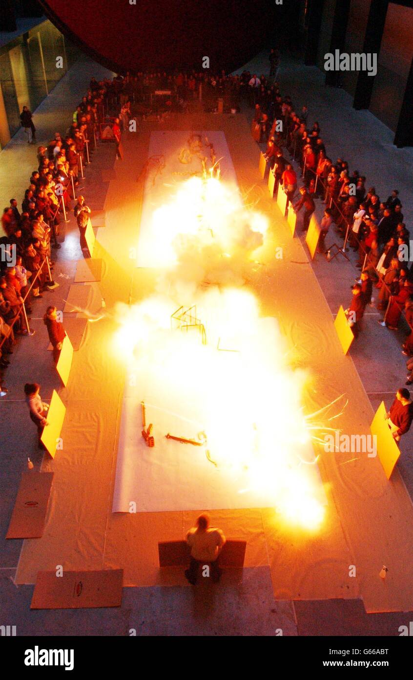 Zuschauer beobachten, wie der chinesische Künstler Cai Guo-Qiang eine seiner gefeierten Gunpowder-Zeichnungen in der Turbinenhalle der Tate Modern entwirft. Die Zeichnungen, die mit schwarzem Schießpulver und Sicherungsdraht in schwerem japanischem Papier verbrannt sind, ähneln großformatigen Radierungen * ..., die in der Tate Modern für die Öffentlichkeit ausgestellt werden. Stockfoto