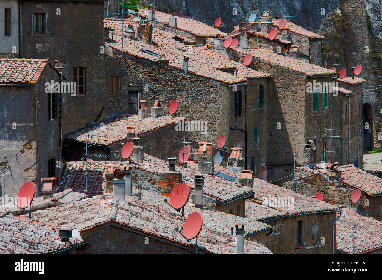 Tv Satellitenschüsseln auf Terrakotta Ziegeldächer in Sovana Stockfoto