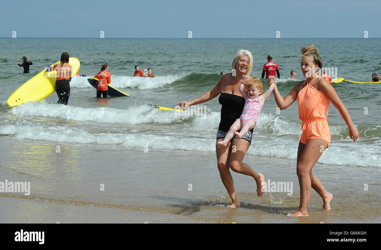 (Von links nach rechts) Sharon Jamesieson (links), Nadia 20 Monate alt und Nadia Jamesieson, 16 Jahre alt, aus North Tyneside Genießen Sie die Sonne am Tynemouth Beach, North Tyneside. Stockfoto