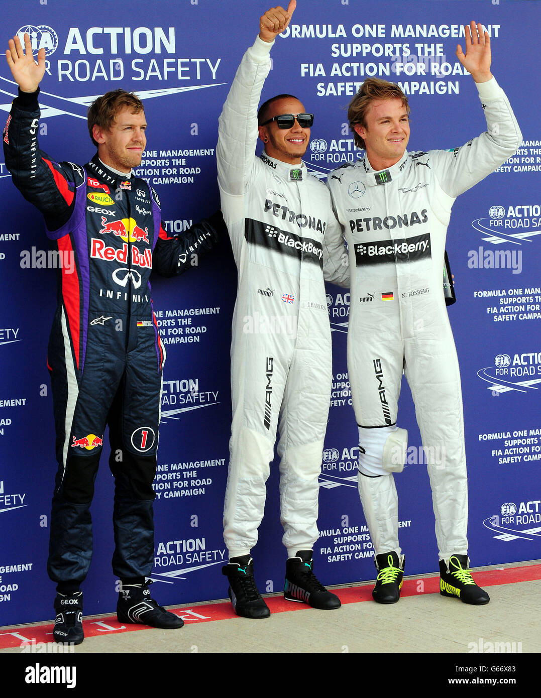 Mercedes Lewis Hamilton feiert nach dem Qualifying auf der Pole Position mit dem zweiten Mercedes Nico Rosberg (rechts) und dem dritten Platz von Red Bull, Sebastian Vettel (links) für den British Grand Prix von Santander 2013 auf dem Silverstone Circuit, Towcester. Stockfoto