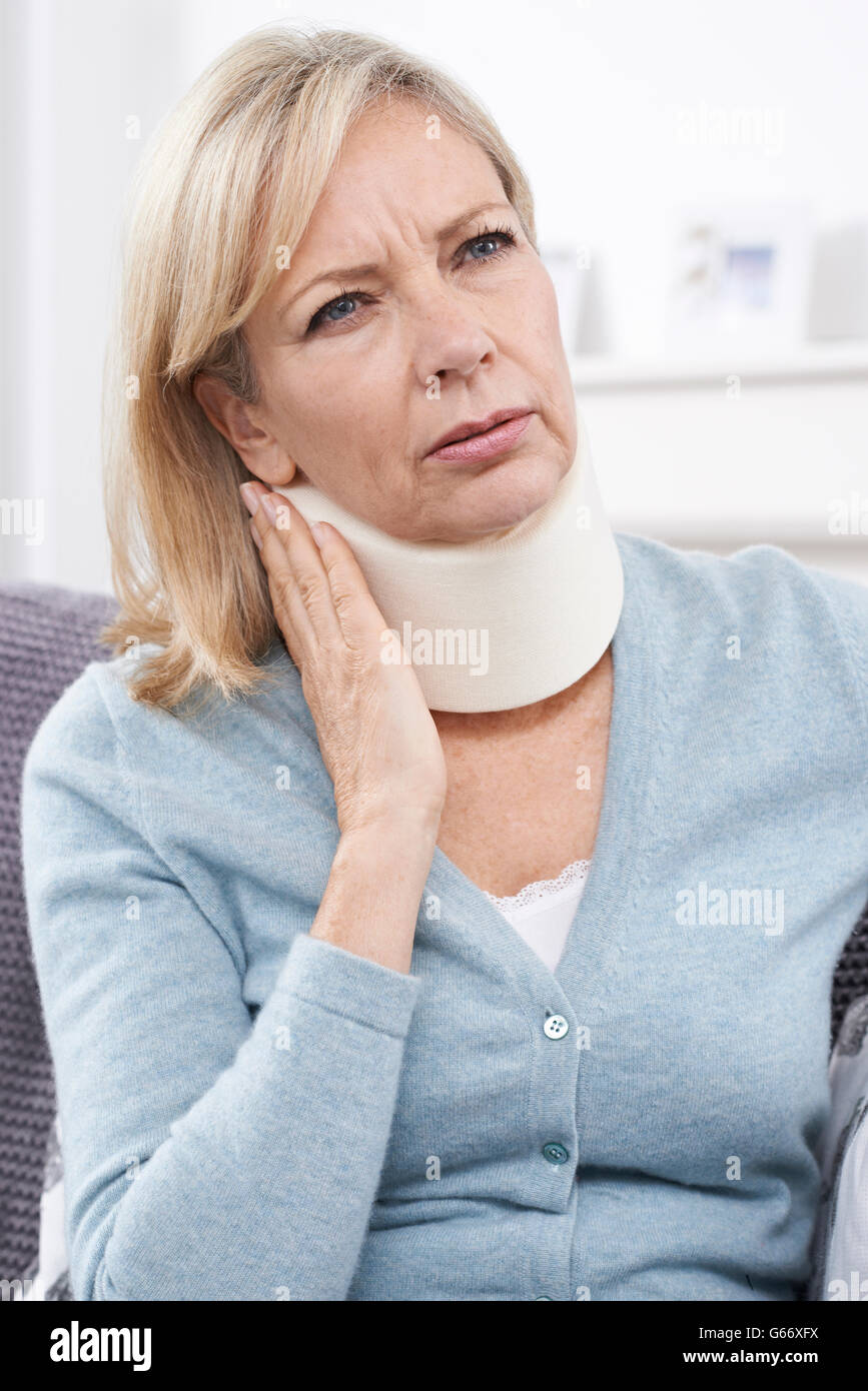 Reife Frau tragen chirurgische Kragen In Schmerzen Stockfoto