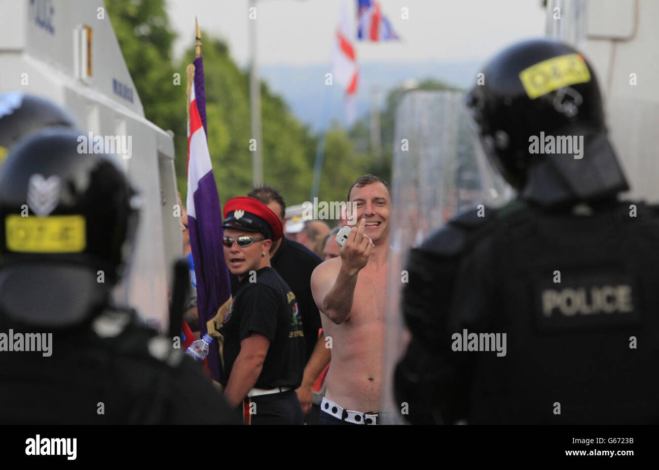 Loyalisten konfrontieren die Polizei in Nord-Belfast, nachdem die von der Regierung ernannte Paraden-Kommission beschlossen hatte, Orangemen davon abzuhalten, durch Ardoyne in Nord-Belfast zu gehen, nach einem Tag friedlicher Feiertagsparaden im zwölften Juli in Nordirland. Stockfoto
