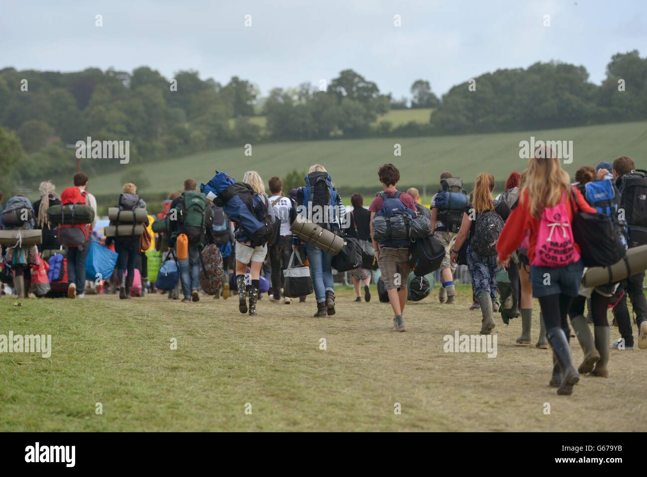 Die Festivalbesucher gehen nach dem Glastonbury 2013 Festival of Contemporary Performing Arts in Worthy Farm, Somerset. Stockfoto