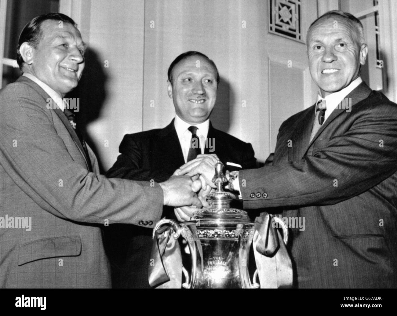 Überreicht den FA Cup, da der neue Manager von Liverpool, Bobby Paisley (links), die guten Wünsche des Clubvorsitzenden John Smith (Mitte) und des scheidenden Managers Bill Shankly erhält, nachdem seine Ernennung auf der Mitgliederversammlung des Clubs angekündigt worden war. Paisley, eine ehemalige Liverpooler Flügelhälfte, ist seit drei Jahren Shankleys Assistent. Stockfoto