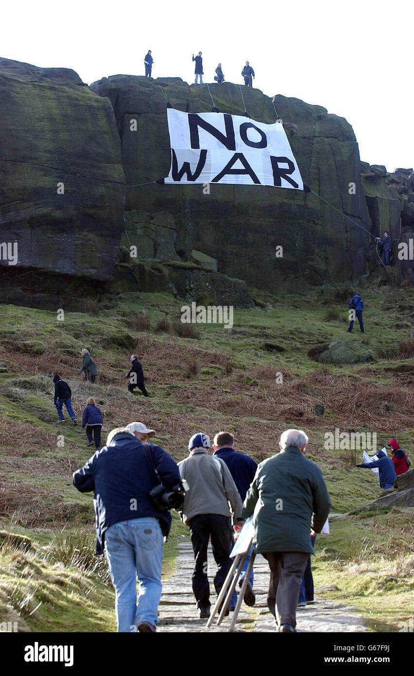 Mitglieder der Ilkley Peace Group aus der Nähe von Leeds bringen ihre Anti-Kriegs-Botschaft an tausende Besucher der Wharfedale-Gegend weiter, nachdem sie ein riesiges Anti-Kriegs-Banner von den berühmten Cow and Calf Rocks auf Ilkley Moor aufgehängt haben. Stockfoto