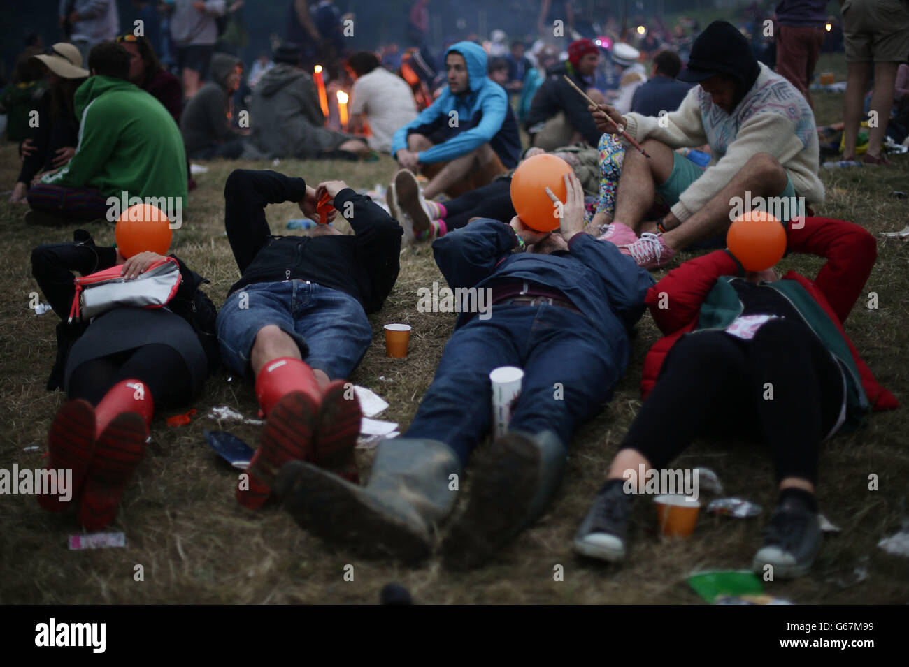 Festivalbesucher im Morgengrauen am Steinkreis, am letzten Tag des Glastonbury Festival of Contemporary Performing Arts 2013 in Worthy Farm, Somerset. Stockfoto