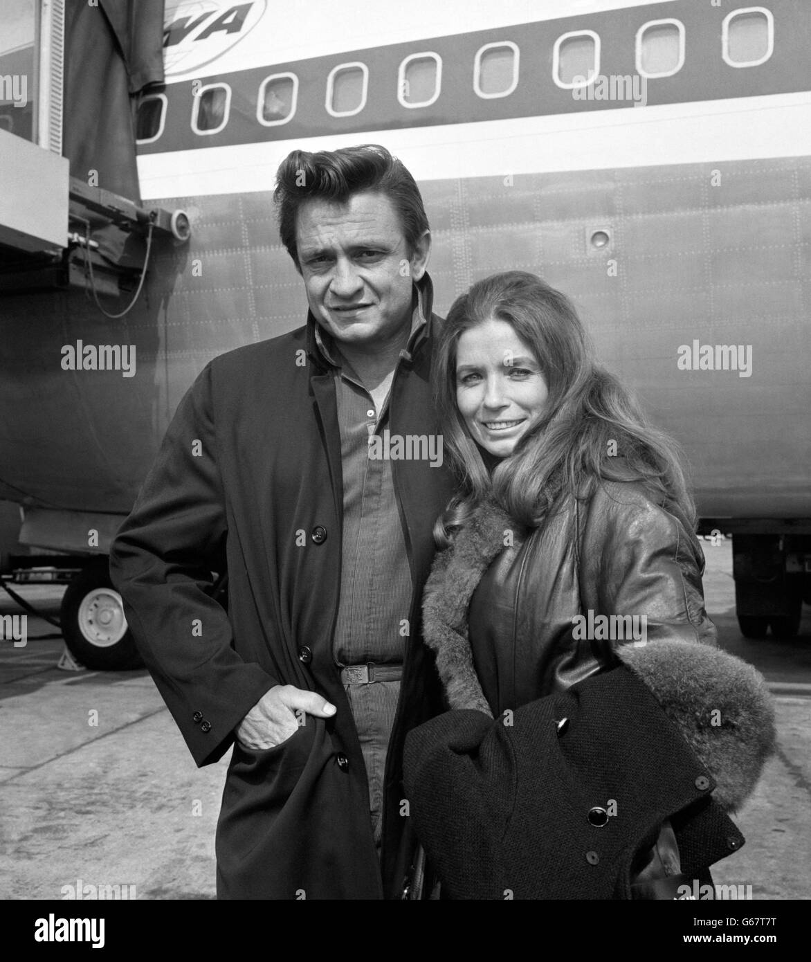 Johnny Cash, der amerikanische Country- und Western-Sänger, im Bild mit seiner Frau June Carter am Flughafen Heathrow in London. Stockfoto