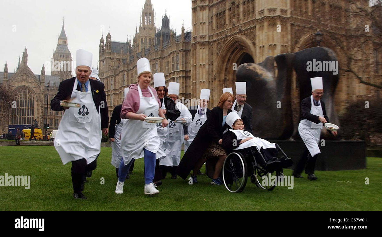 Das parlamentarische Pfannkuchen-Rennen beginnt, als Mitglieder des Unterhauses und des Oberhauses es es um Meter vom Parlament kämpfen. Das Rennen wurde im Auftrag der Organisation Rehab UK für Hirnverletzungen durchgeführt. Stockfoto