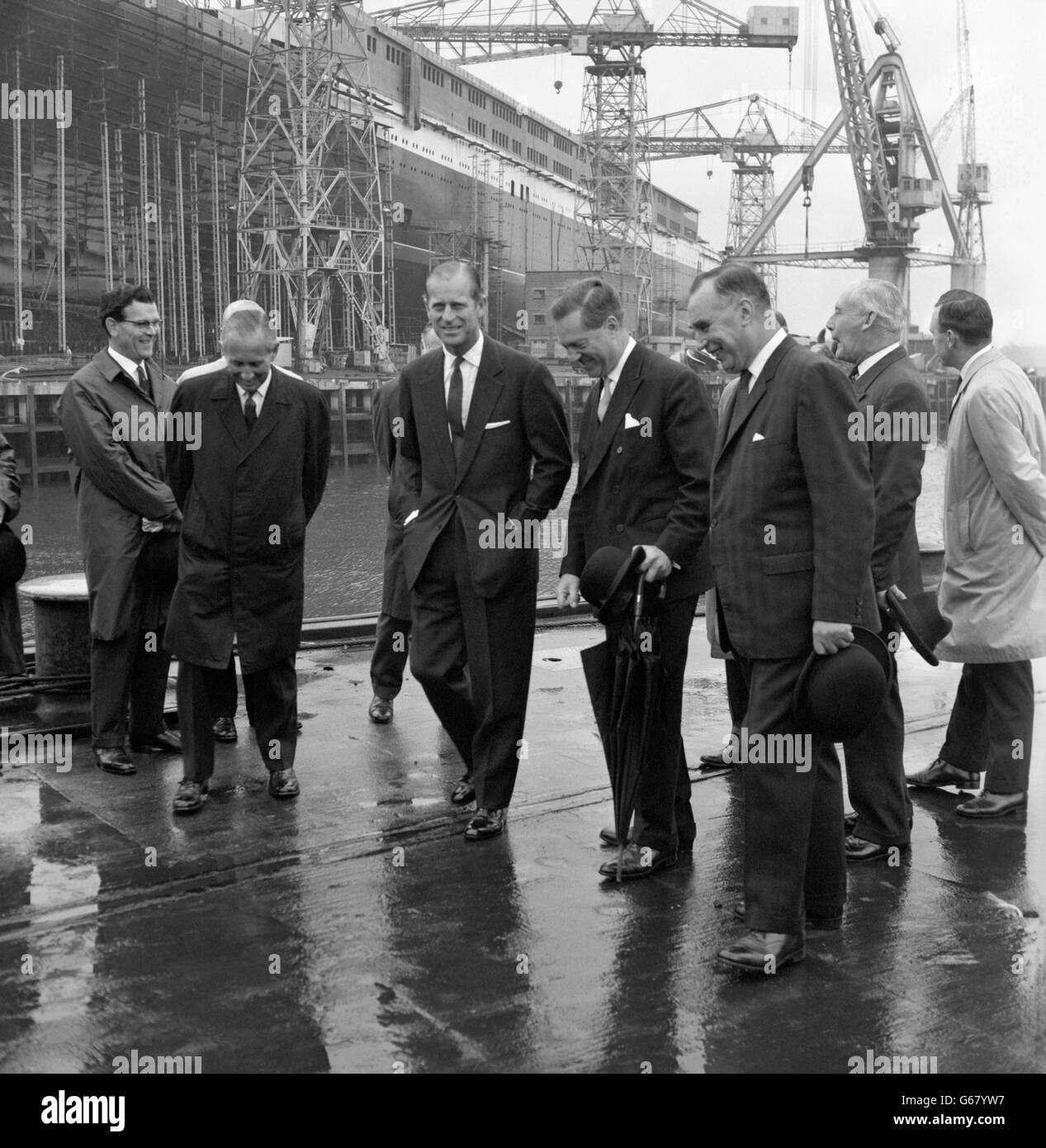 Prinz Philip, der Herzog von Edinburgh, besucht den neuen riesigen Cunard-Linienschiff Q4 und wird heute von Lord Aberconway, Chairman von John Brown's (Mitte), mit John Rannie, John Brown's Managing Director (rechts), um John Brown's Shipyard, Clydebank, Schottland, gezeigt. Der Herzog besuchte die Werft für seinen ersten Blick auf die Q4, die die Königin zu nennen und starten am 20. September ist. Stockfoto