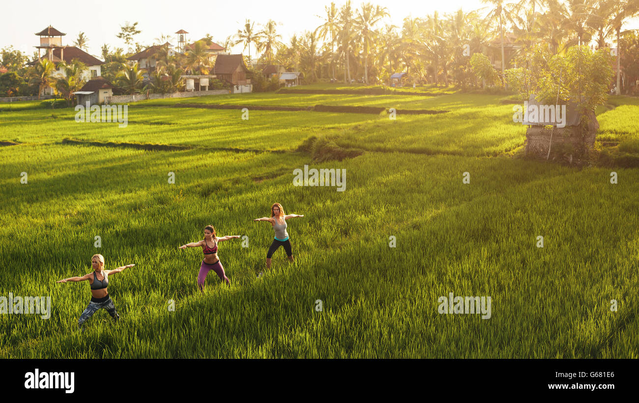 Fitness-Frau Yoga im Hof im Freien zu tun. Yoga-Kurs in landwirtschaftlicher Flächen. Stockfoto