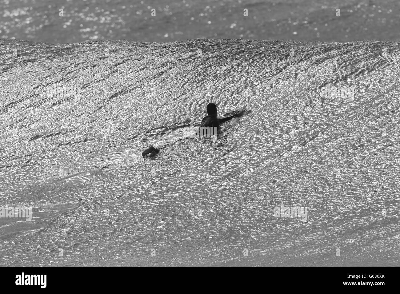 Surfen Surfer nicht identifizierten Paddel über Ozean Welle Vintage schwarz / weiß Stockfoto