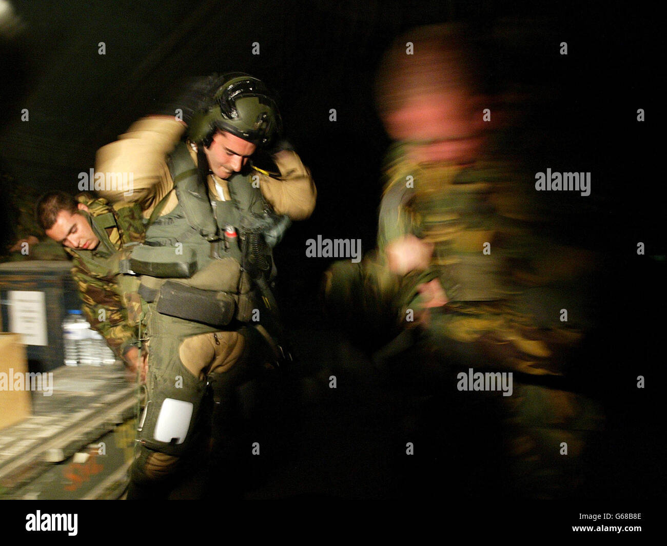 Im Ansturm einer Luftangriffswarnung wird der Royal Air Force Squadron Leader Jim Provost (zweiter links) von Safety Equipment Monteuren in einem Bunker auf ihrer Basis in Kuwait für seine Mission vorbereitet. * US-amerikanische und britische Truppen drangen über Nacht in den Irak ein und überquerten die Wüstengrenze von Kuwait unter dem Deckmantel einer intensiven Artilleriesperre, als ein zweiter Luftangriff Ziele in Bagdad schlug. Stockfoto