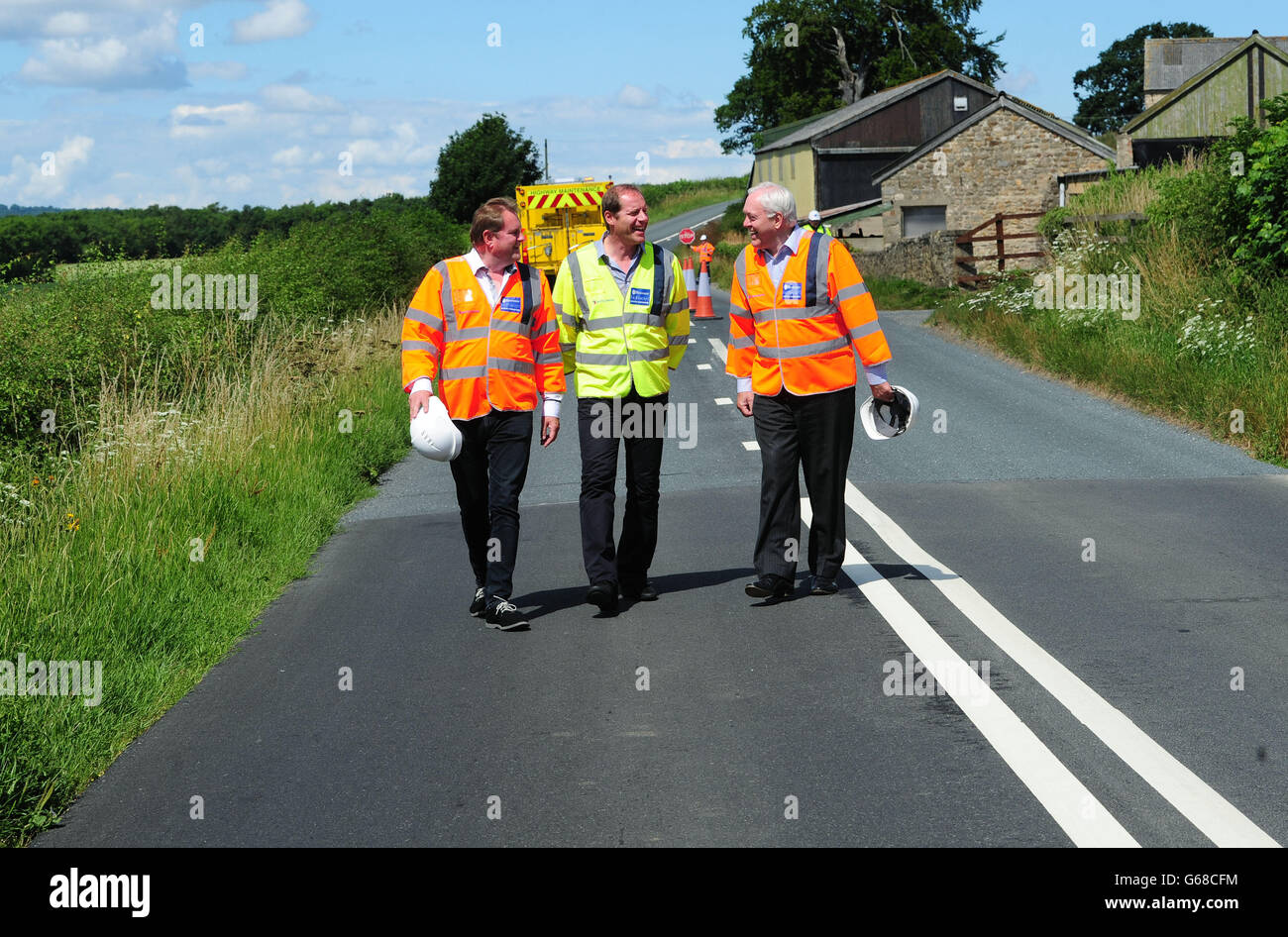 Willkommen bei Yorkshire-Chef Gary Verity (links), Tour de France-Direktor Christian Prudhomme und North Yorkshire County Council-Chef John Weighell (rechts) studieren die neu verlegte Straßenoberfläche in der Nähe von West Tanfield, Ripon, da Autobahnen vor dem Start der Tour de France in Yorkshire im Jahr 2014 vorbereitet werden. Stockfoto