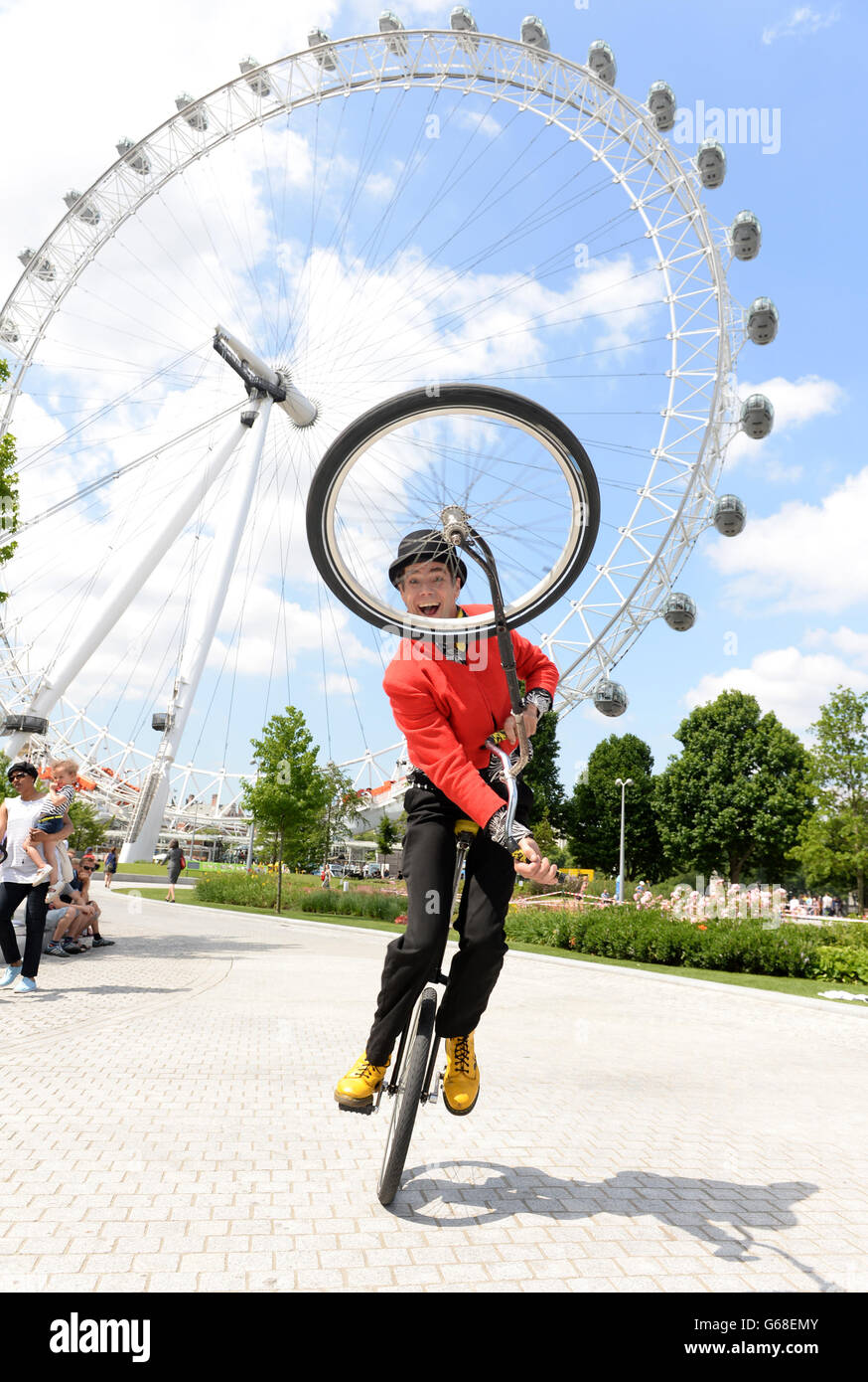 Ein Zirkus-Straßenunterhalter tritt vor dem EDF Energy London Eye auf. DRÜCKEN Sie VERBANDSFOTO. Bilddatum: Freitag, 12. Juli 2013. Den ganzen Sommer über werden Stelzenläufer, Einradfahrer und Akrobaten im London Eye auftreten, um die Menschenmassen zu unterhalten. Bildnachweis sollte lauten: Doug Peters/PA Wire Stockfoto