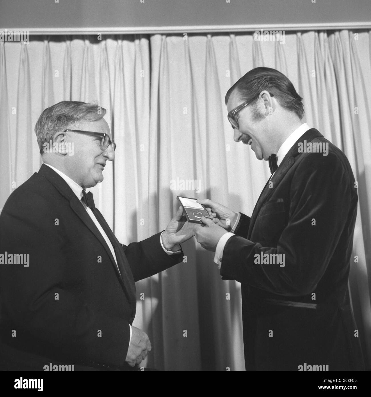 Der TV-Reisejournalist Alan Whicker erhält eine Silbermedaille der Royal Television Society, die er bei der Verleihung der jährlichen Auszeichnungen der Gesellschaft während des jährlichen Balls der Gesellschaft im Dorchester Hotel, Park Lane, London, erhielt. Whicker wurde während der BBC-Dokumentarserie „Whicker's World“ für herausragende künstlerische Verdienste vor der Kamera ausgezeichnet. Stockfoto