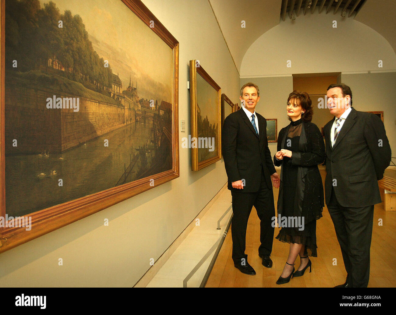 Der britische Premierminister Tony Blair, Left, zusammen mit seiner Frau Cherie und dem deutschen Bundeskanzler Gerhard Schröder sehen Arbeiten in der Ausstellung "Meisterwerke aus Dresden" in der Royal Academy of Art in London. * Herr Schroeder besuchte Herrn Blair, um über neue Resolutionen der Vereinten Nationen zum Irak zu diskutieren. Stockfoto