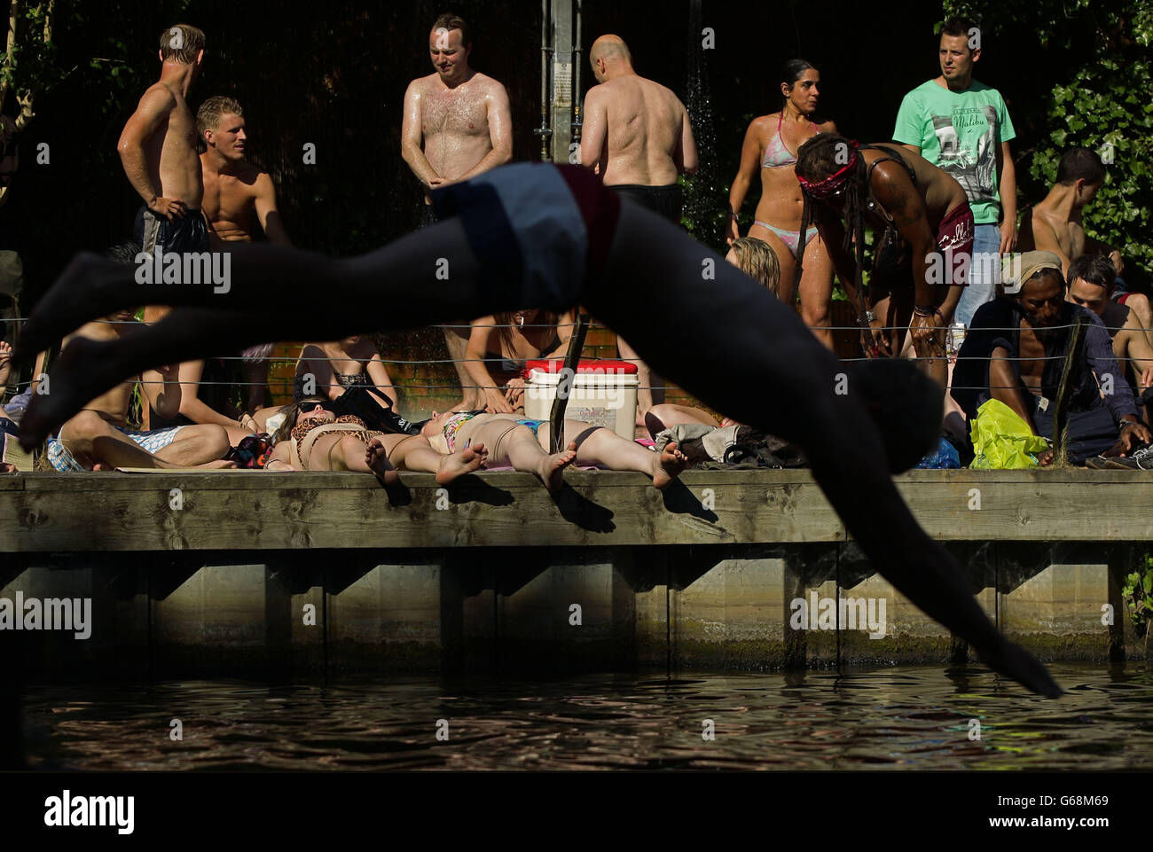 Schwimmer und Sonnenanbeter genießen das heiße Wetter in den gemischten Badeteichen von Hampstead Heath im Norden Londons. DRÜCKEN Sie VERBANDSFOTO. Bilddatum: Freitag, 19. Juli 2013. Bildnachweis sollte lauten: Yui Mok/PA Wire Stockfoto