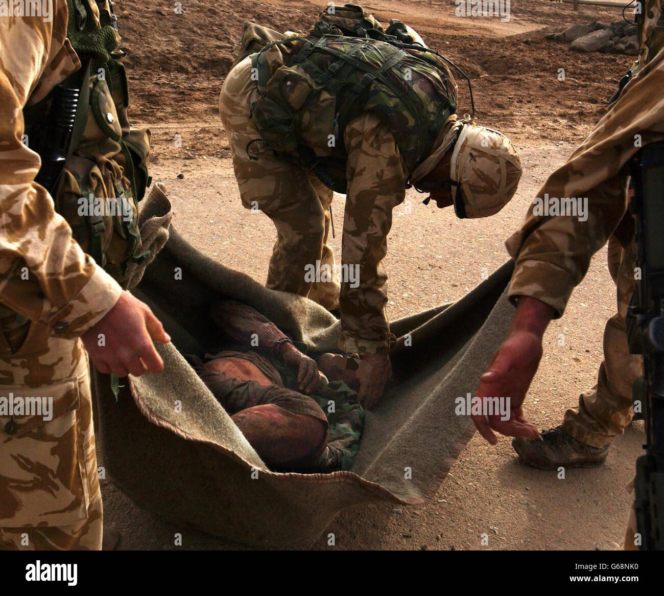 Ein Royal Marine Commando von 40 Commando Royal Marines zeigt Mitgefühl mit einem schwer verletzten irakischen Soldaten heute Morgen auf dem Al Faw Peninisular. Stockfoto