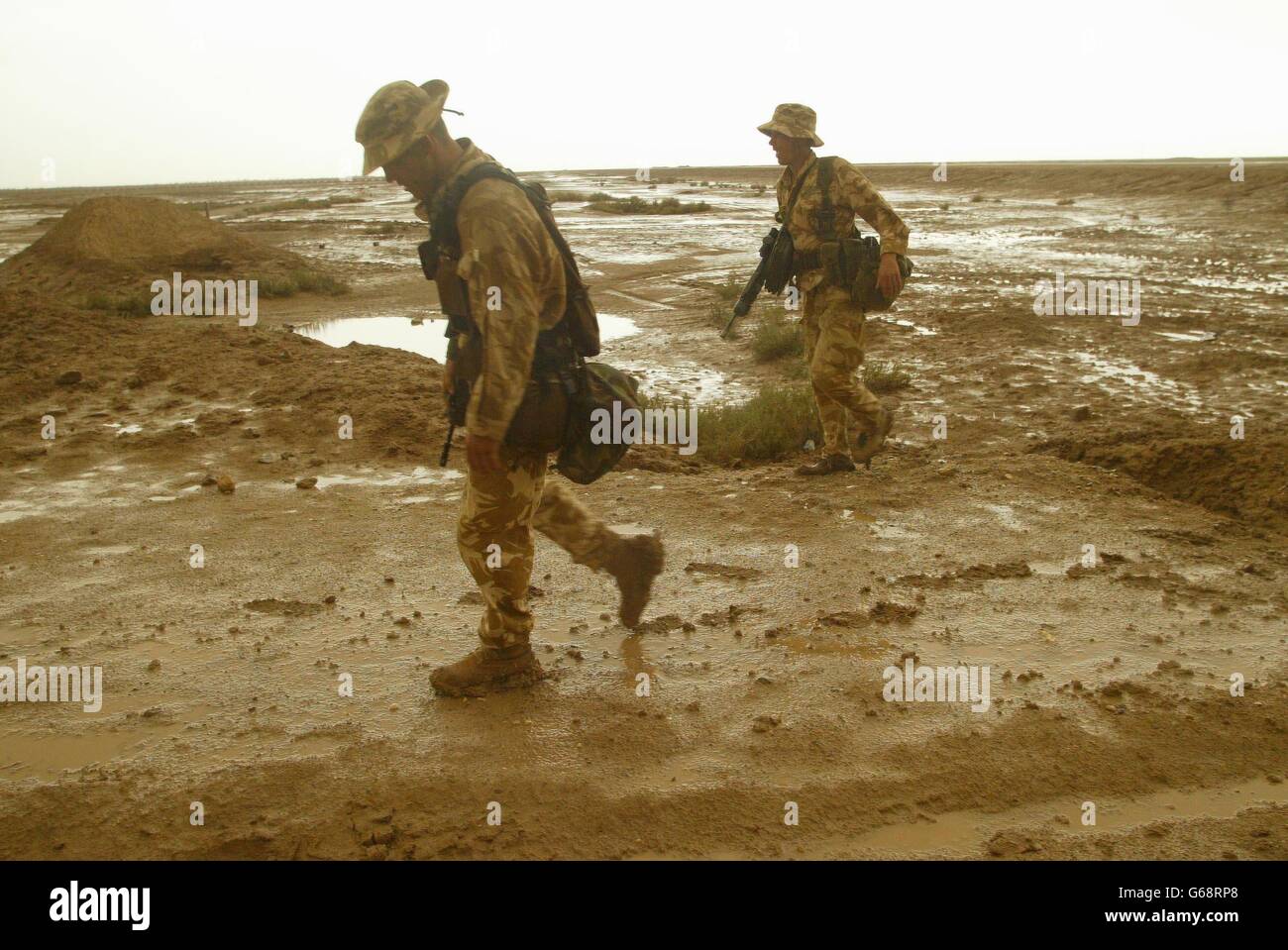 Mitglieder von 40 Royal Marines des Commando gruben nördlich der Halbinsel Al Faw, um Basra zu erreichen, nachdem starke Regenstürme die Wüste in Schlammebenen verwandelt hatten. Stockfoto