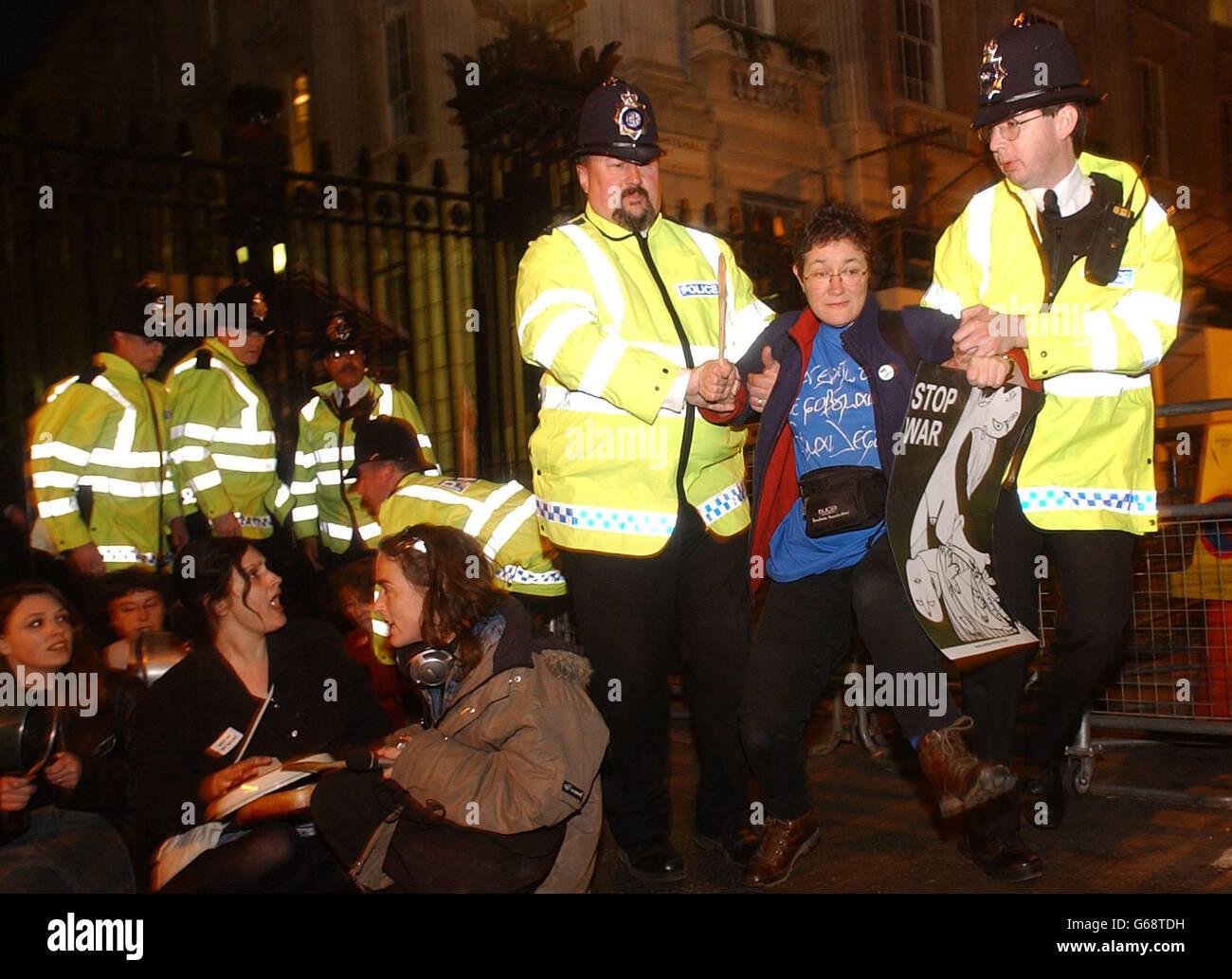 Eine Frau wird während eines Protestes gegen den Krieg im Irak von der Polizei weggeführt, bei dem vor den Toren der Downing Street im Zentrum Londons Kochtöpfe geschlagen wurden. Stockfoto