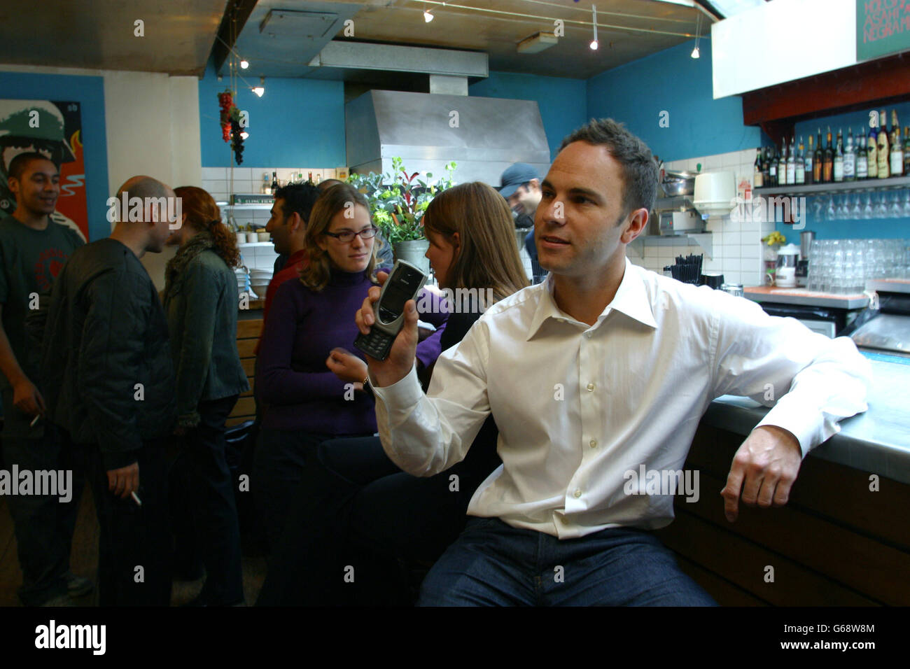 Shazam.  Um die Aufmerksamkeit der Stella Kramer.  Chris Barton, Gründer und Business Development Director der Shazam, nutzt sein Handy, um der Name der die Musik spielt in 'Alpabet' Bar im Londoner Soho zu erfassen.  Foto von Jonathan Player für die New York Times, 10. Oktober 2002 Stockfoto