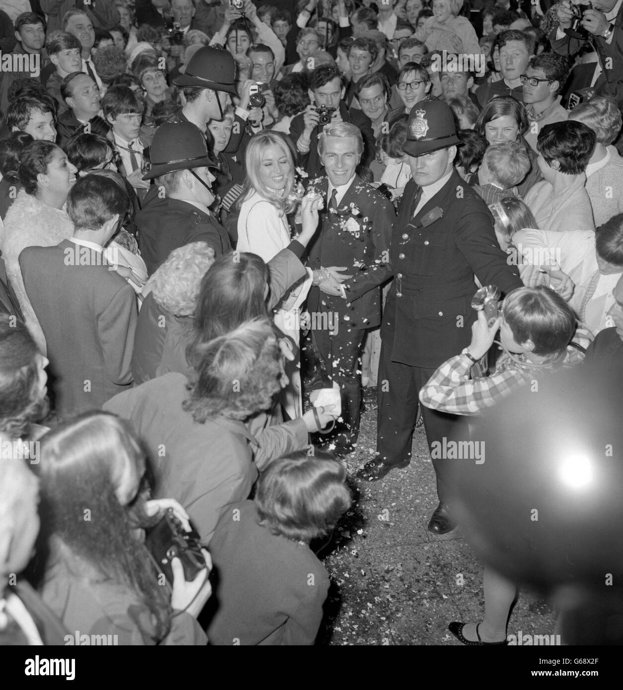 Als das mit Konfetti bedeckte Pop-Idol Adam Faith die in Blackpool geborene Tänzerin Jackie Irving in der Caxton Hall, London, verhandelte, wurden Polizisten gezwungen, eine große Menge von Faith-Fans zurückzuhalten. Stockfoto