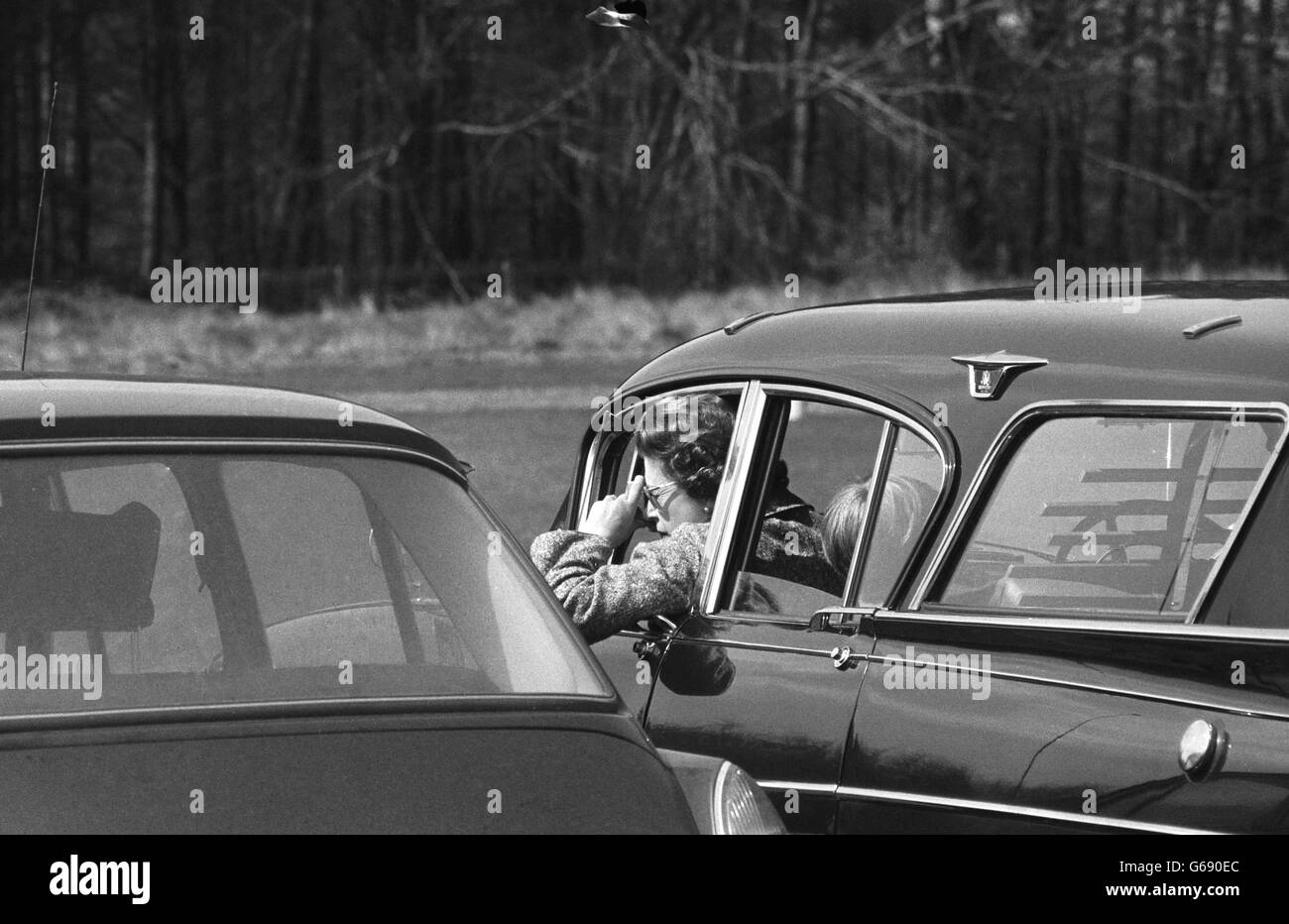 Königin Elizabeth II. Lehnt sich aus ihrem Auto, um ihre Tochter, Prinzessin Anne, auf dem Pferd ihrer Mutter, Columbus, zu fotografieren. Stockfoto