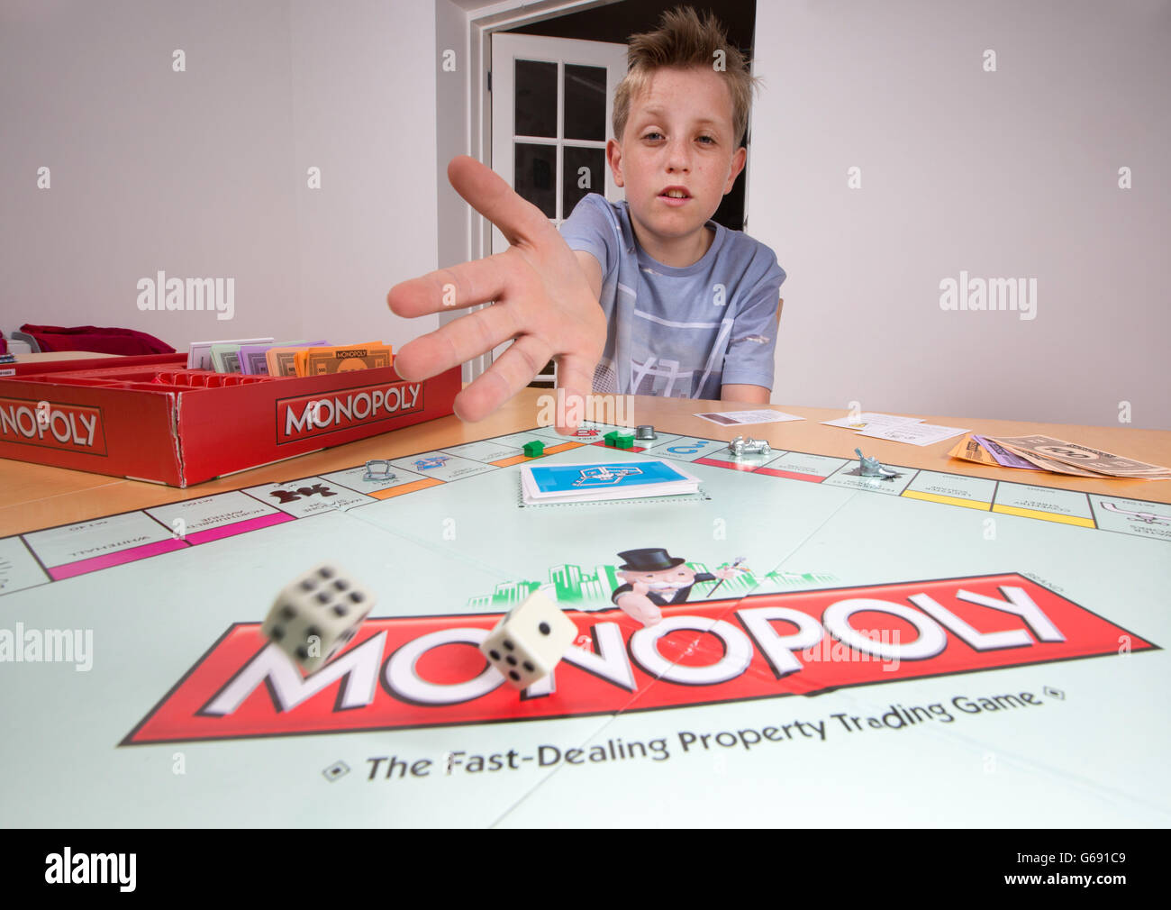 Ein Junge spielt das Brettspiel Monopoly Stockfoto