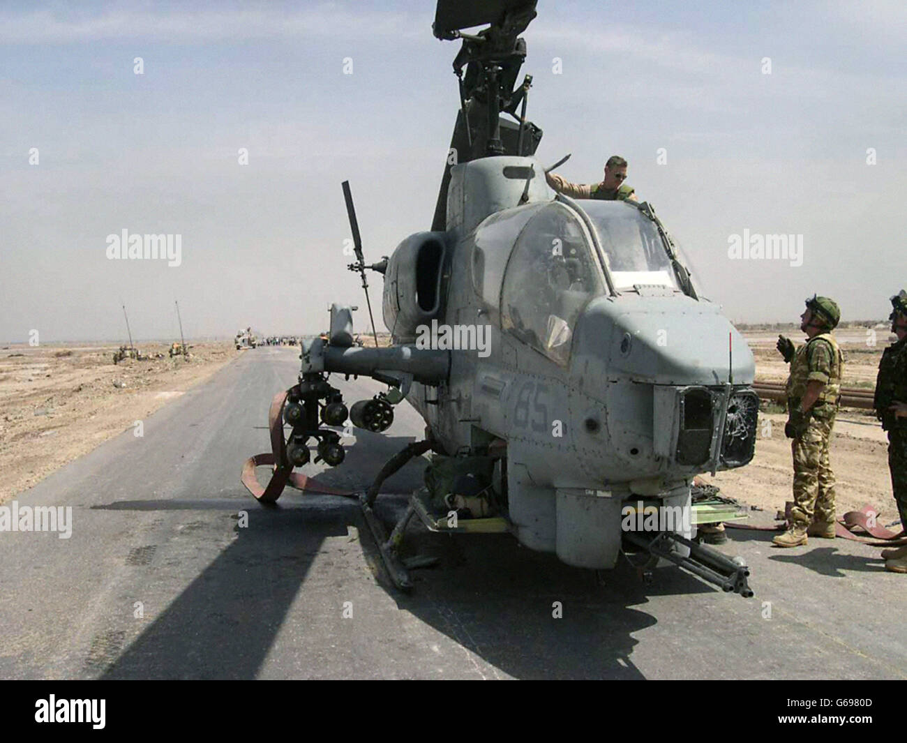 Britische Black Watch-Soldaten mit einem Cobra-Hubschrauber, der auf einer Straße nach Basra, Südirak, abgeschossen wurde. Stockfoto
