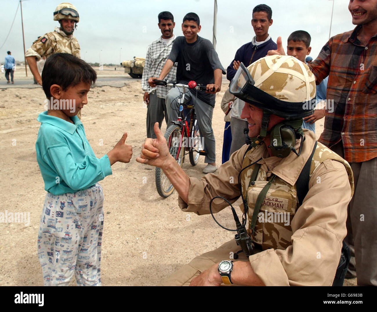 LT. Col. Hugh Blackman von der Royal Scots Dragoon Guards wird von einem lokalen Jungen in Basra, Irak, die Tumbs gegeben.PA Photo/Daily Record/Tony Nicoletti/mod POOL. Stockfoto