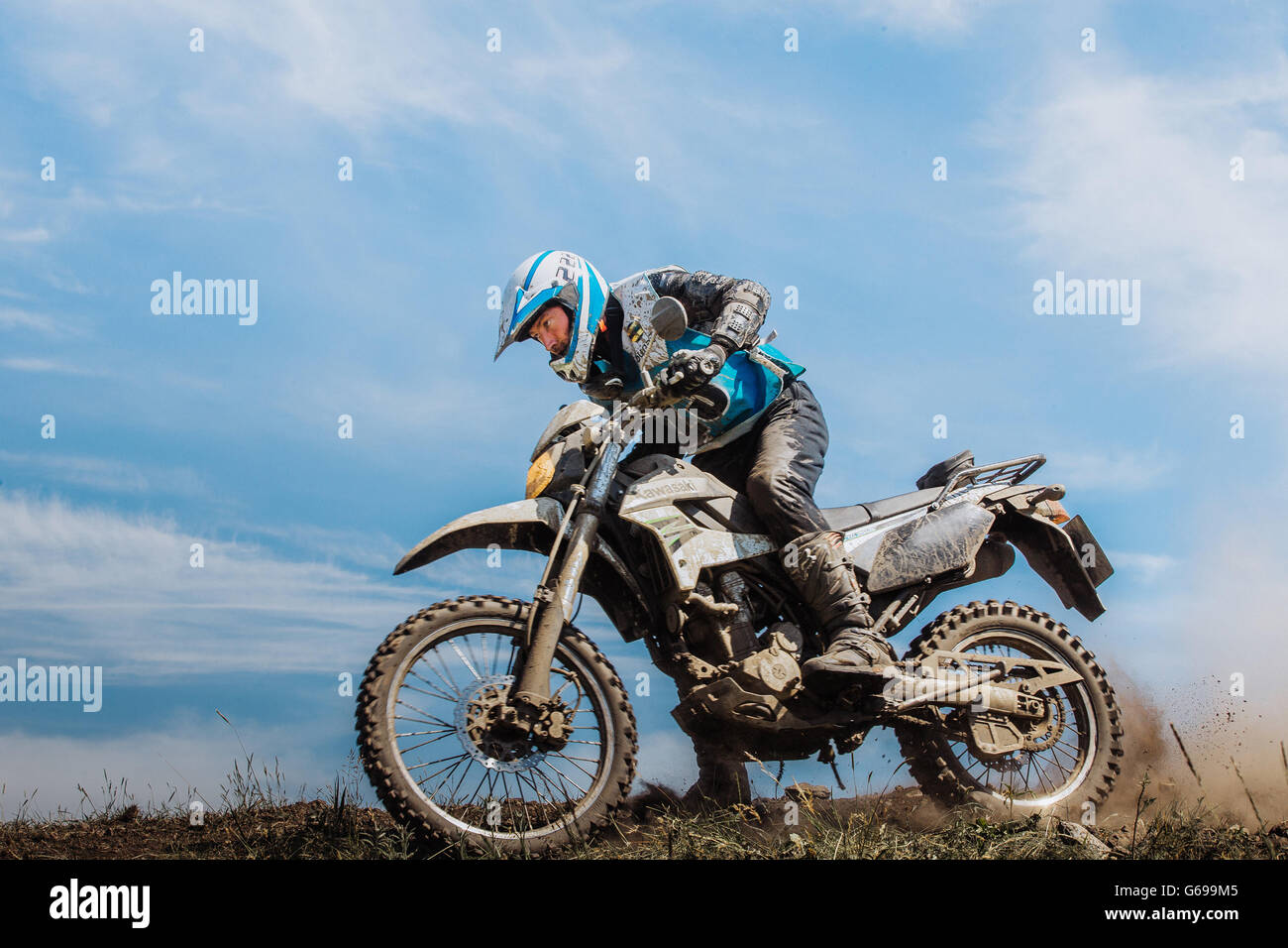 Biker auf Berg unter Hinterräder von Schlamm und Steinen während Ural Cup in Enduro Stockfoto