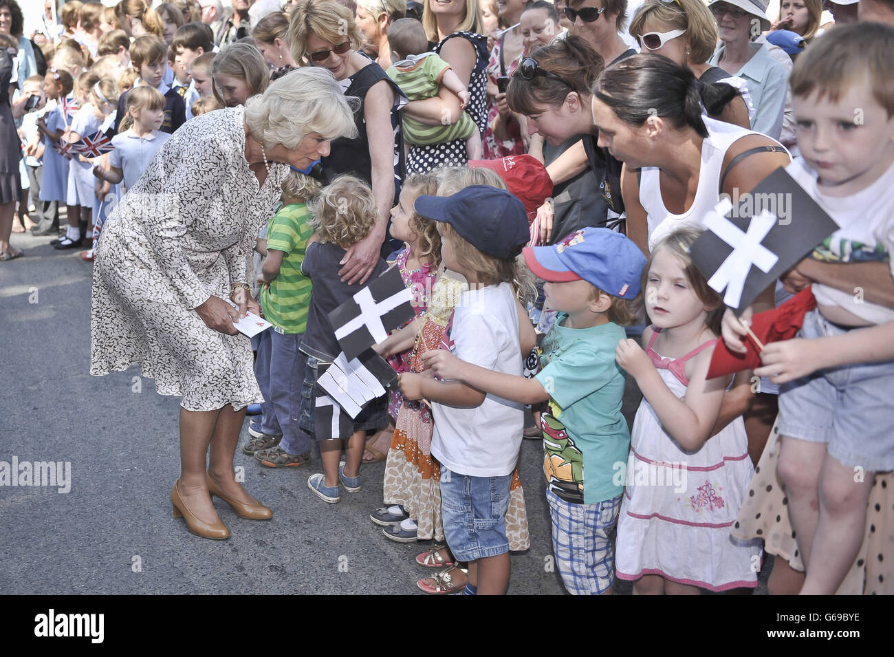 Ihre königliche Hoheit, die Herzogin von Cornwall, die ihren 66. Geburtstag feiert, trifft Kinder, die ihre eigenen kornischen Fahnen auf den Straßen von Lostwithiel gemacht haben, während die Herzogin und der Prinz an ihrem jährlichen Sommerbesuch in Cornwall und Devon teilnehmen. Stockfoto